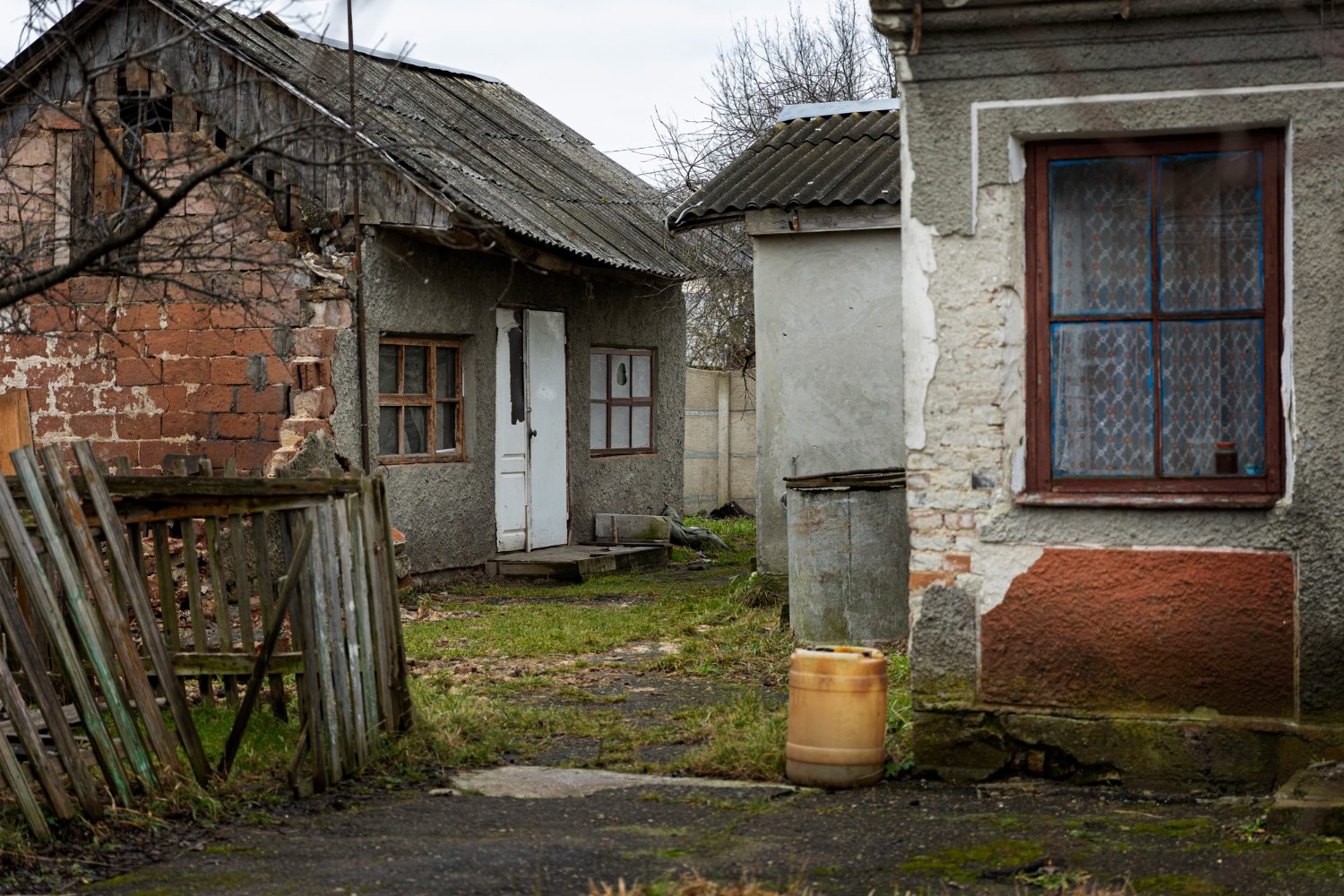 Deserted And Decaying House With A Broken Fence And Overgrown Yard